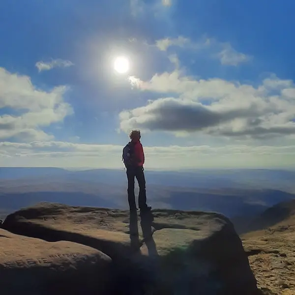 Person stood on a rock over a valley