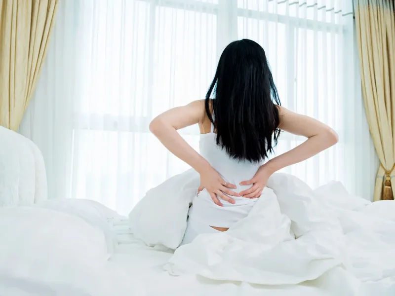 Woman holding her back in pain